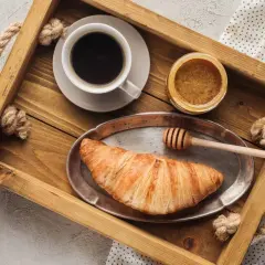 Kawa z miodem i rogalikiem na drewnianej tacy. Czy kawa z miodem jest zdrowa? Pyszne śniadanie.
