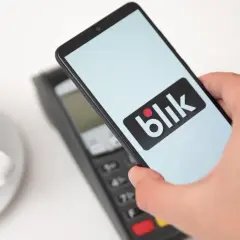 Zbliżeniowa płatność telefonem z logo Blik. Kawa czeka, a transakcja przebiega błyskawicznie.