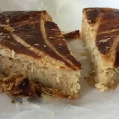 Deux parts de galette des rois coco, avec leur feuilletage doré et leur garniture généreuse, prêtes à être dégustées.