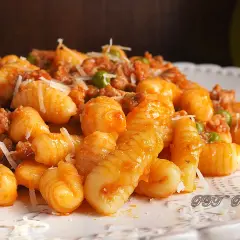 Gnocchetti sardi con ragù e piselli, un piatto gustoso ispirato alle ricette della Sardegna.