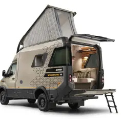 Hymer Venture S z podniesionym dachem i otwartym tyłem, ukazujący przytulne wnętrze z kanapą i poduszkami.