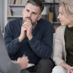 Para rozmawia z terapeutą, który notuje.