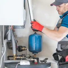 Instalator sprawdza podzespoły kotła gazowego, by dowiedzieć się, dlaczego piec gazowy buczy.