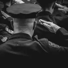 Policjanci w mundurach salutują. Dbanie o czystość munduru, jak prać mundur wojskowy, to ważny element służby.