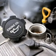 Korek silnika z napisem "ENGINE OIL" i symbolem kropli oleju. Pamiętaj o wymianie oleju co 2 lata dla sprawnego działania silnika.