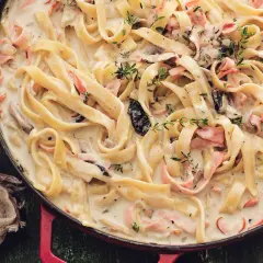 Tagliatelle w kremowym sosie z kawałkami szynki i grzybów, pachnące tymiankiem. Pyszne mac and cheese w nowej odsłonie.