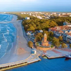 Malownicza miejscowość nad morzem z latarnią morską, plażą i molo.