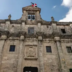 Kamienne mury Alcázaru de Colón, symbolu stolicy Dominikany, Santo Domingo. Flaga powiewa nad dzwonami.
