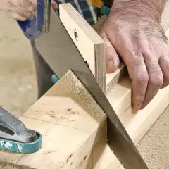 Händer använder en geringssåg och en handsåg för att kapa trä. Olika sågar kan användas för exakta snitt.