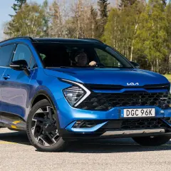 Blå Kia Sportage, en begagnad bil som testas i soligt vårväder.