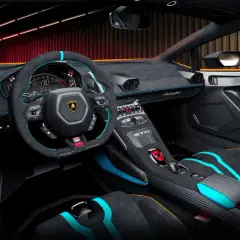 Wnętrze Lamborghini Huracan STO: sportowe fotele, kierownica z alcantary i włókna węglowego, cyfrowe zegary.