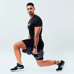 Uomo con manubri esegue affondi, un esercizio che rientra nel concetto di amrap significato: "as many reps as possible".