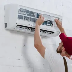 Técnico instalando un aire acondicionado inverter, ajustando filtros.