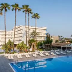 Basen i leżaki przy hotelu TUI Suneo Santa Ponsa. Palmy i biały budynek hotelowy na tle błękitnego nieba.