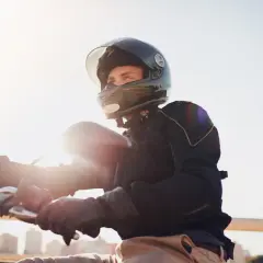 Giovane con casco integrale, pronto a partire in motorino. L'obbligo casco motorino è fondamentale per la sicurezza.