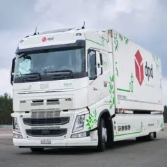 Biała ciężarówka elektryczna DPD z zielonymi liśćmi i symbolem wtyczki, świadcząca o jej ekologicznym charakterze. Zasięg takich pojazdów jest kluczowy dla przyszłości transportu.