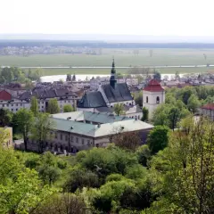 Widok na Pińczów z górującym kościołem i klasztorem. W oddali pola i lasy. Odkryj pińczów atrakcje!