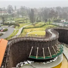 Wieliczka miasto. Drewniane tężnie solankowe tworzą malowniczą spiralę, a w tle widać zabudowania i park.