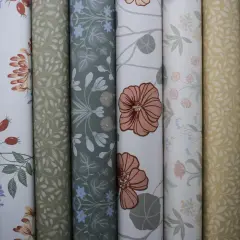 Rullar med vackra tapeter i olika mönster, inspirerade av naturen. Här finns blommor, blad och bär i harmoniska färger. En av tapeterna visar ett mönster av Hanna Wendelbo.