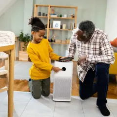 A boy and his grandfather learn how to test air quality in your home using a modern air purifier.