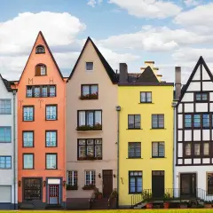 Bunte hausfassade farbe beispiele: Gelb, Weiß, Orange, Beige, Gelb, Weiß und Rosa Häuser reihen sich aneinander.