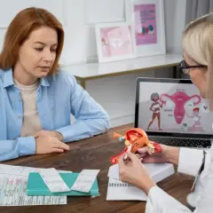 Lekarka wyjaśnia pacjentce model anatomiczny, omawiając objawy i leczenie adenomiozy.