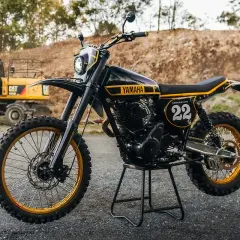 Yamaha XT 500 Dakar, negra y dorada, lista para la aventura. Excavadora CAT al fondo.