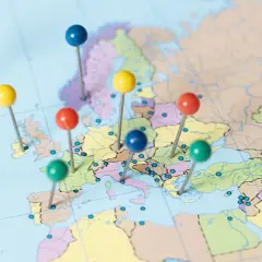 Kolorowe pinezki zaznaczone na mapie Europy, wskazujące potencjalne kierunki podróży po najbezpieczniejszych krajach świata.