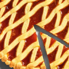 Torta con marmellata, la pasta frolla dorata e croccante è perfetta per la cottura. Due fette sono già state tagliate.