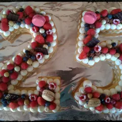 Gâteau chiffre 25 décoré de chantilly mascarpone, framboises, fraises, myrtilles, macarons et chocolat.
