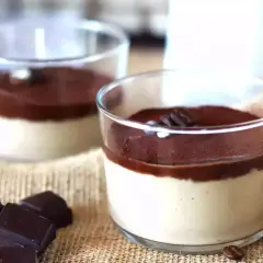 Deliziosa ganache al caffè espresso in bicchierini, guarnita con cacao e chicchi di caffè. Accanto, pezzi di cioccolato fondente.