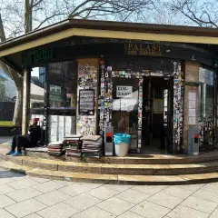 Der "Palast der Republik Stuttgart" ist ein Kiosk, der mit vielen Stickern beklebt ist. Eine Person sitzt davor.