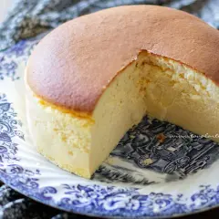 Un soffice cheesecake giapponese, leggero e arioso, servito su un piatto decorato con un motivo blu e bianco.
