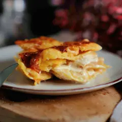 Ein Stück cremiges Kartoffelgratin mit goldbrauner Kruste auf einem Teller, bereit zum Genießen. Dieses Kartoffelgratin Rezept ist ein Genuss!