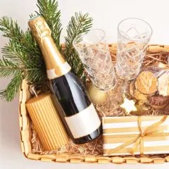 Festliche Fresskorb Ideen: Sektflasche, Gläser, Kerze, Kekse und Geschenk.
