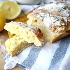 Pain de mie levure chimique, doré et saupoudré de farine, avec des citrons frais à côté.