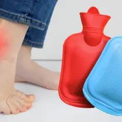 Schmerzende Ferse mit roter Markierung und Wärmflaschen. Was tun gegen Fersenschmerzen? Wärme kann helfen.
