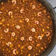 Arroz del senyoret en paellera, con gambas, trozos de calamar y patata. Un plato generoso y lleno de sabor.