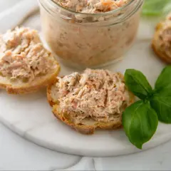 Pyszna pasta rybna na chrupiących grzankach, ozdobiona świeżą bazylią. Idealna na szybką przekąskę.
