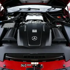 Le capot ouvert révèle le puissant moteur AMG d'une Mercedes rouge. Ce moteur, bien que différent d'un moteur Renault, est une merveille d'ingénierie.