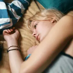 Två unga kvinnor ligger nära varandra, en med blont hår och en med mörkt. En scen som påminner om svenska ungdomsfilmer från 90-talet.