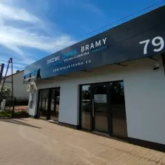 Nowoczesny salon okien i drzwi z szyldem "DRZWI OKNA BRAMY" i numerem 79a.