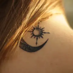 Tatouage lune et soleil sur la nuque, en phase de cicatrisation, une légère croûte est visible.