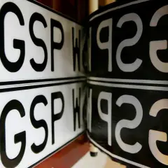 Dwie polskie tablice rejestracyjne, jedna biała z literami GSP i PL, druga czarna. Brak rejestracji.