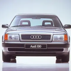 Klasyczne Audi 100 z lat 90. prezentuje się elegancko na jasnym tle.