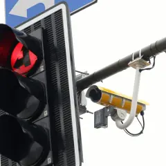 Czerwone światło sygnalizacji świetlnej ze strzałką w lewo i kamerą rejestrującą.