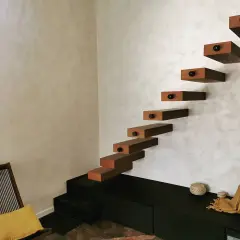 Escaliers flottants en bois sur un mur texturé, une belle deco peinture murale moderne.