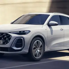 Białe Audi Q5 2025 z nowym grillem i reflektorami porusza się po drodze.
