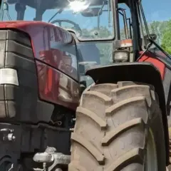 Zwei Männer besprechen den Einsatz eines Traktors. Der jüngere schaut aufs Handy, der ältere hält eine Mappe. Ein guter Verdienst als Fachkraft Agrarservice ist wichtig.