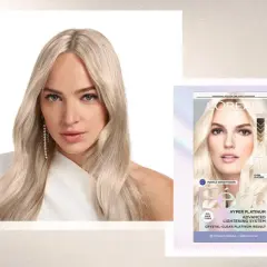 Mujer con pelo rubio platino, resultado de decoloración pelo. Caja de tinte L'Oréal Féria Hyper Platinum.
